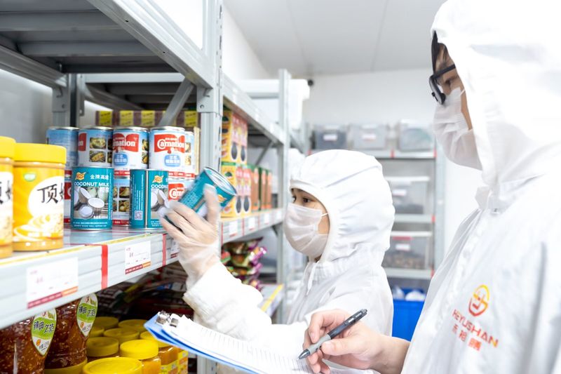 仓库管理区，工作人员盘点罐头及调味品库存