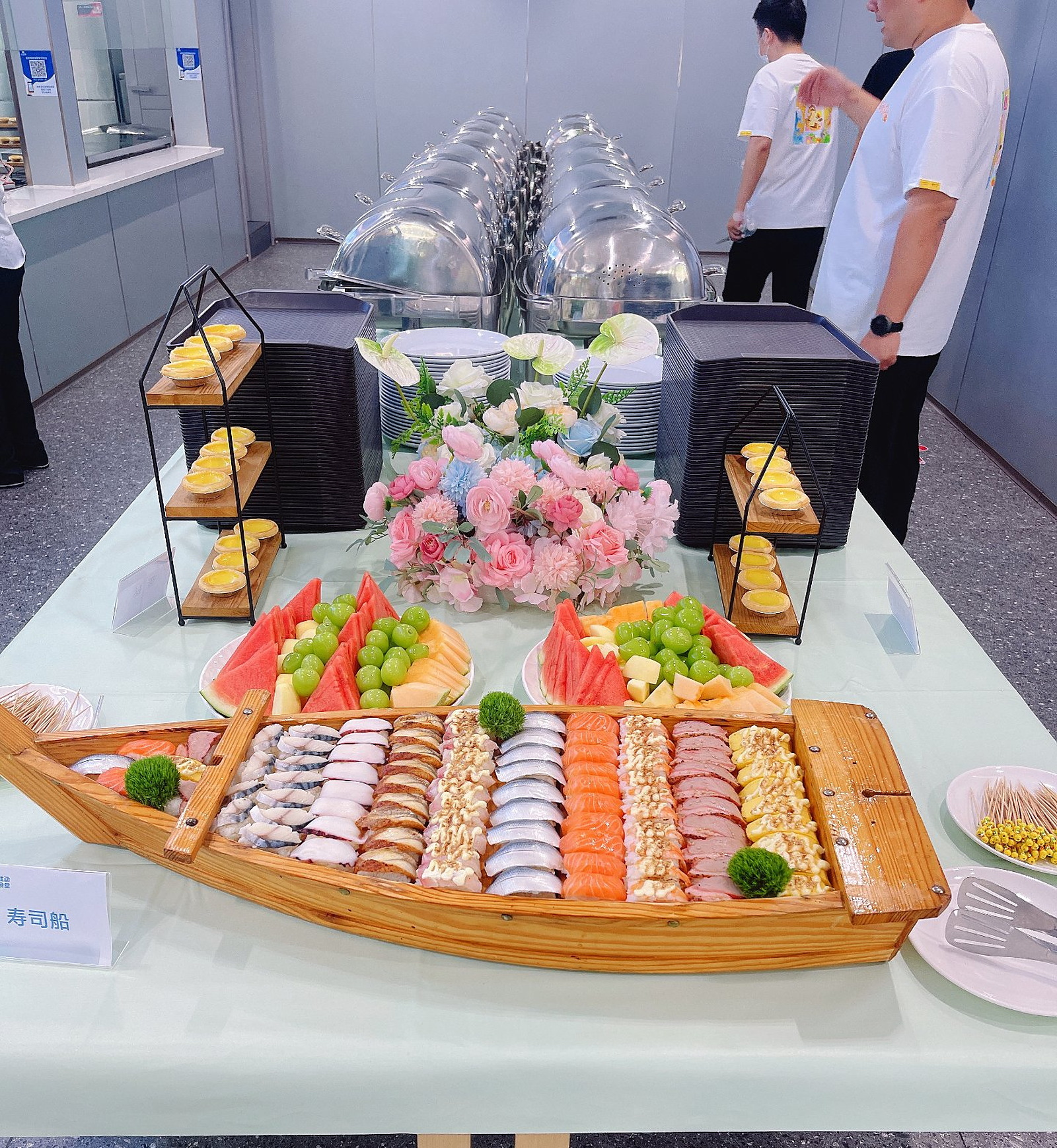 家庭日自助餐台：寿司船、蛋挞与水果台，搭配粉玫瑰蓝绣球花艺